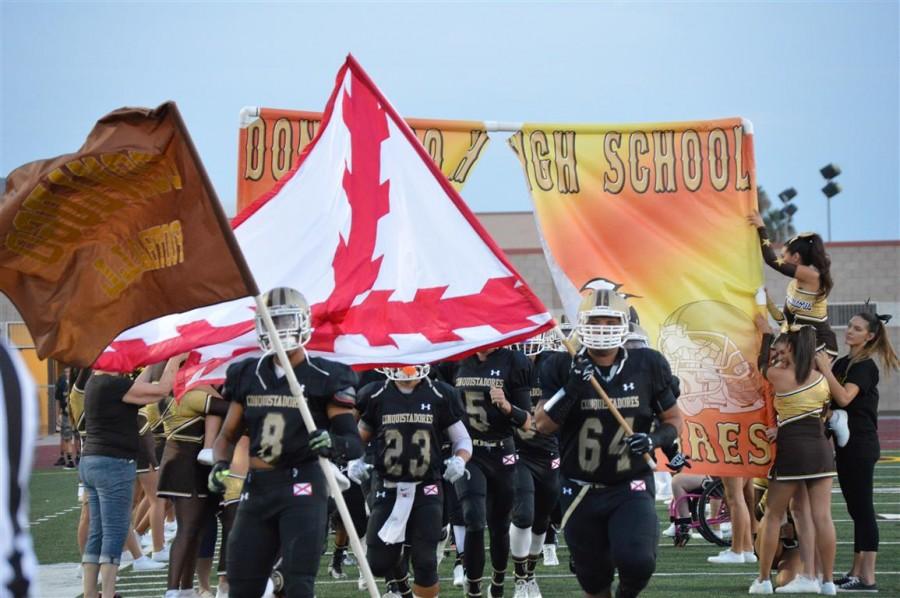 The Don Lugo Conquistadors storm the field with their brand new black-out kit.With Tzion Dixon waving the Don Lugo Conquistador flag and Chris Torres waving the Flag of Burgundy.Our football team take the field hoping to gain a victory over The Rancho Cucamonga  Cougars.