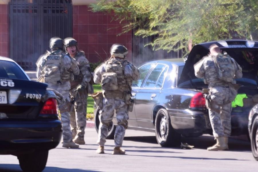SWAT officers surround the scene of a deadly San Bernardino shooting. A man identified as Marc stated that his wife saw bodies on the floor when she and others left the building. Multiple suspects remain at large.