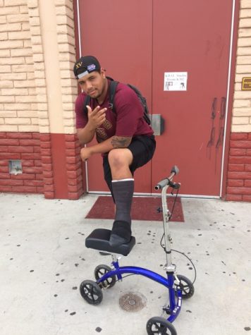 Chris Torres posing with his brand new cast and scooter for mobility around campus.  I believe in my team and I know theyll get the job done, Torres confidently mentioned. 