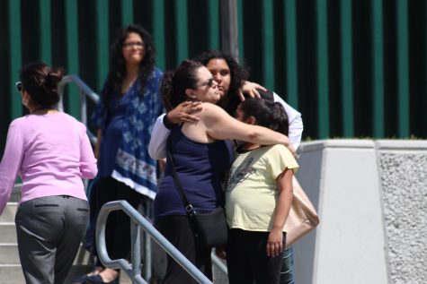 A mother is reunited with her 2 daughters after a lengthy check-out process to insure the safety of the students that remained in the multi-purpose room of Cajon High School. 