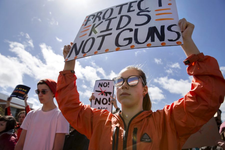 Ellie Bloom, 17, a junior at Tamalpais High School in Mill Valley, holds up a protest sign reading Protect kids, not guns during the March for Our Lives march and rally in Richmond, CA on Saturday March 24, 2018. -Picture courtesy of Public Domain