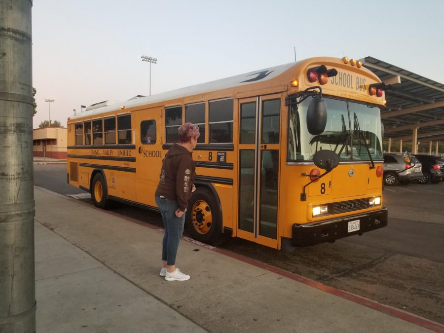 Teacher greeting Don Lugo students while they arrive to school and exist the bus early in the morning (Photo Credit Patricia Redaelly)