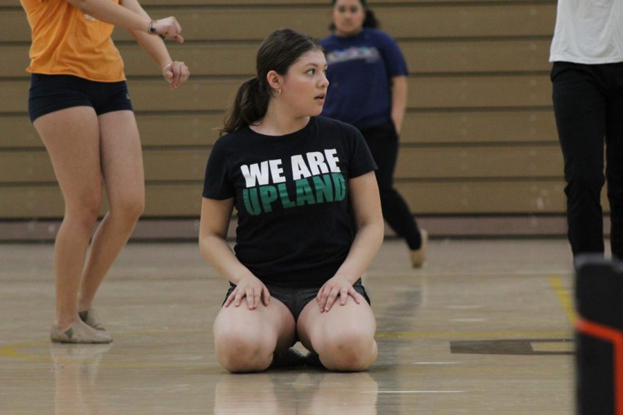 A dance team member resting after preforming a difficult stunt in her choreography. 