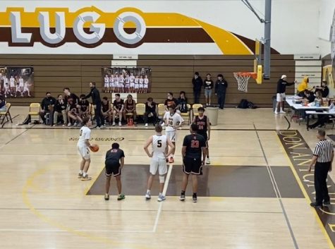 Isaiah Yoguez is positioned right at the free throw line, hoping to make the next basket to help his team win.  Luke Kemble, #5, is looking at Yoguez as he stands on the lane line ready to grab the rebound.