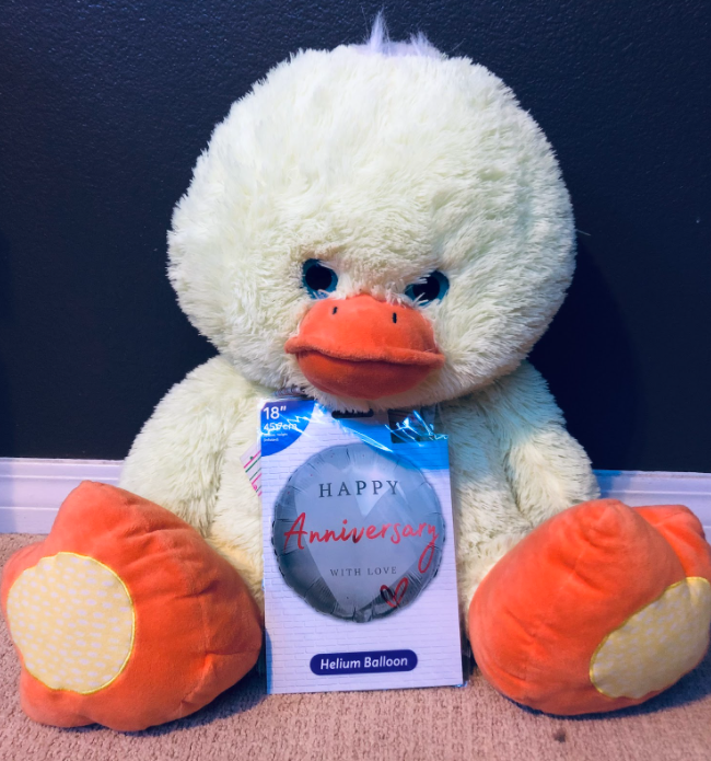 Photo of a duck stuffed animal with an anniversary balloon. 