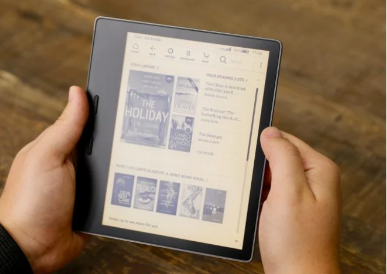 Image of Kindle Oasis (2019) being held by trusted reviews.