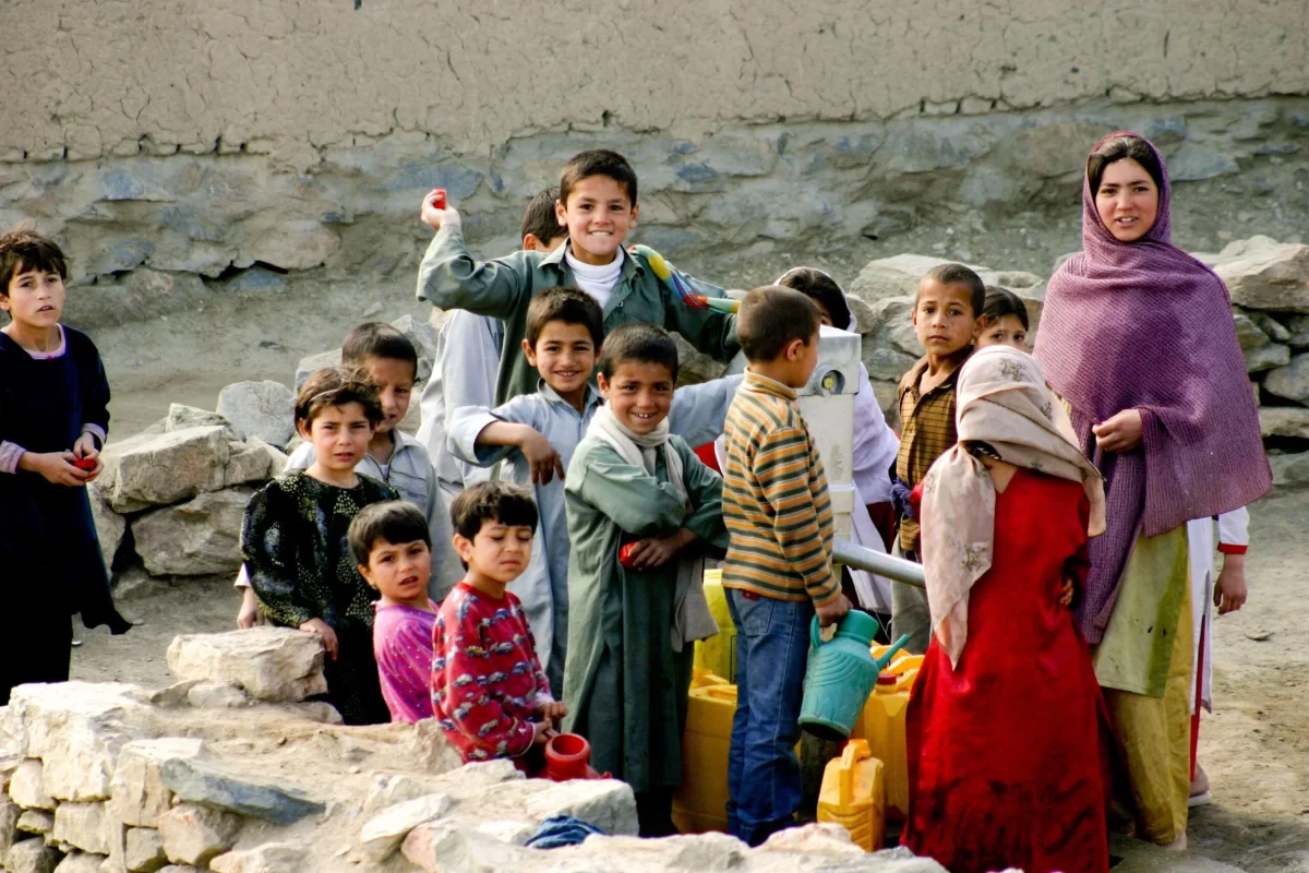 14 Afghan Refugee children with an older woman.